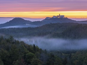 View from Rennsteig across the Thuringian Forest to Wartburg at dawn, morning fog in the valleys,