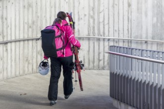 Woman with skiing equipment, Zweisimmen, Switzerland