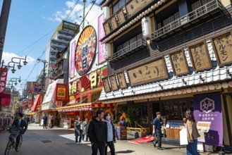 Lots of colorful signs in a pedestrian zone with shops and restaurants, Shinsekai, Osaka, Japan