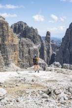 Hikers on the Sentiero Brentari hiking trail in front of cliffs, Brenta Mountains, Brenta-Adamello