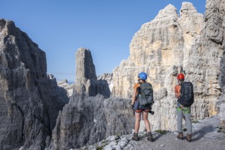 Mountaineers look at Campanile Alto pinnacle, Bocchette Centrale band trail, via ferrata in the