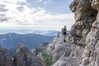 Climbers on a rock band, Bocchette Centrale band trail, via ferrata in the Brenta Mountains,