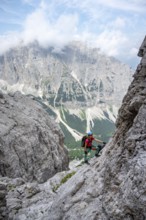Female mountaineer on rock face, rocky mountain landscape, Via Ferrata SOSAT via ferrata, Brenta