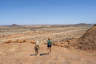 Bushman's paradise, tourist and guide hiking through the vast, dry desert landscape, Spitzkoppe,