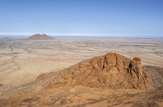 Red rocks against an endless desert landscape and blue sky in Spitzkoppe, Spitzkoppe, Namibia
