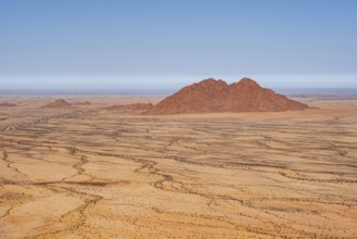Silhouette of a rocky mountain in the middle of the vast, dry desert landscape, Spitzkoppe, Namibia