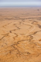 Aerial view of a vast, dry desert with distinctive soil patterns, Spitzkoppe, Namibia
