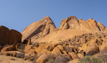 Monumental sandstone mountains rise into the clear desert sky, Spitzkoppe, Namibia