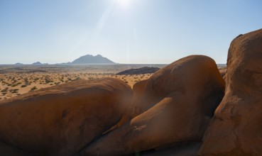 Sunny desert landscape with view of distant mountain range, Spitzkoppe, Namibia