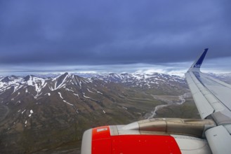 Airplane wing and aerial view over Adventdalen in summer, 30-kilometre valley and river