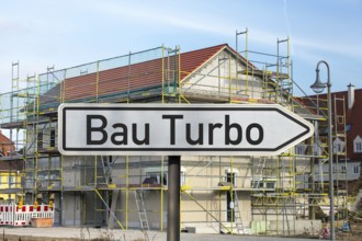 (Photo montage) Direction arrow with the inscription BAUTURBO in front of the construction site of