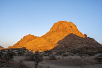 Rocks at sunset in the Namibian desert glow intensely orange, Spitzkoppe, Namibia