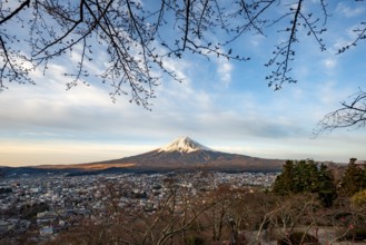View of Mount Fuji volcano over Fujiyoshida City in morning light, at sunrise, Arakurayama Sengen