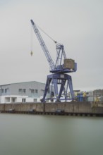 View of a crane standing directly at a harbor basin, Bremerhaven, Bremen, Germany