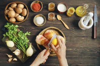 Top view of hans grating lemon zest over raw chicken. Person marinates chicken with dry aromatic