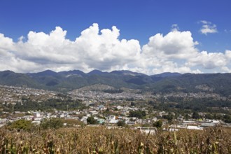 City view of Nahualá between green mountains, in front of a corn field, highlands, Sololá