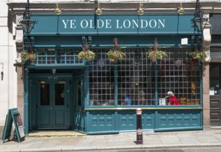 Traditional London pub Ye Old London with green façade and hanging flowers, London, England, Great