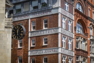 Historic brick building with clock and lettering from newspaper publishers such as Dundee Evening