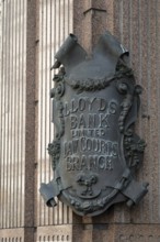 Lloyds Bank coat of arms like metal sign in decorative style on stone wall, London, England, Great