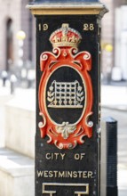 Decorative column with date 1928 marks border with the City of Westminster with coat of arms and