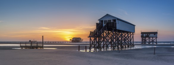 Stilt houses at low tide on the beach at sunset, St. Peter-Ording, Schleswig-Holstein Wadden Sea
