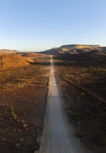 Aerial view, infinite space, straight road leads through dry desert landscape, hills in Damaraland,