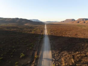 Aerial view, infinite space, straight road leads through dry desert landscape, hills in Damaraland,