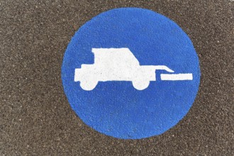 Tractor, front loader, pictogram on the asphalt, agricultural traffic, traffic signs on the dyke,