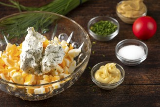 Cream cheese and ingredients for egg cream placed in a bowl