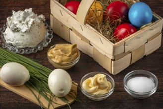 Different ingredients including colorful Easter eggs and cream cheese on a table