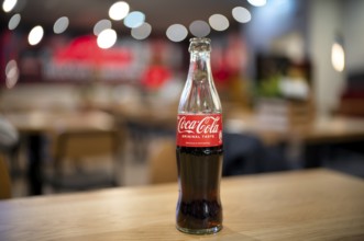 Coke, Coca-Cola, bottle, 0.3 liter, half full, half empty, standing on a table, restaurant, bar,