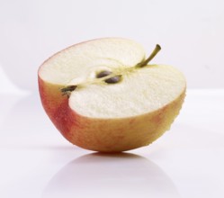 Half of an apple (Malus domestica) in front of a white background, studio shot