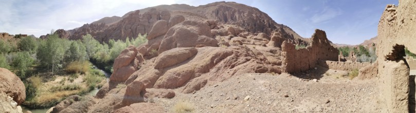 Extensive panorama of rocks and ruins in a dry desert landscape under blue sky, Morocco