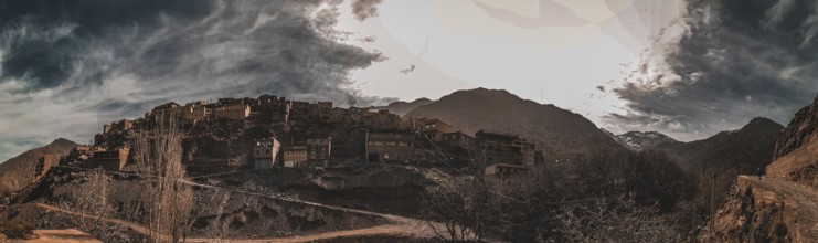 A dramatic panorama of a mountain village with dark clouds in the sky, Atlas Mountains, Morocco