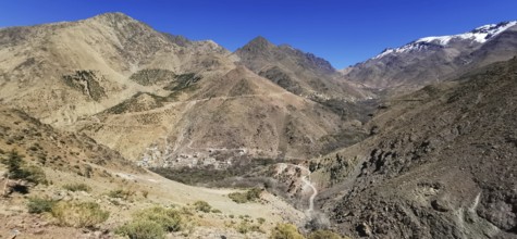 Breathtaking view of a village in a rocky mountain landscape with snow-covered grips under clear