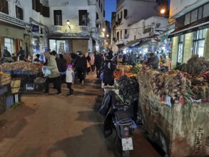 Close market in the Medina in the evening, lively with many people and stalls selling products,