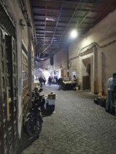 Quiet alley at night with market stalls and lamp light in the Medina of Marrakech, Morocco