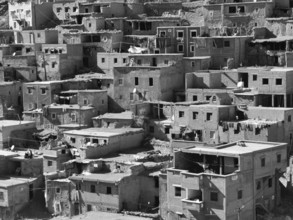 Dense collection of old, winding buildings in an oriental settlement, black and white photo,