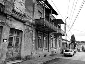 Deserted street with old, dilapidated buildings and a nostalgic parked classic car, car,