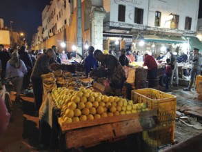Colourful night market with numerous stalls, illuminated with the hustle and bustle of people in