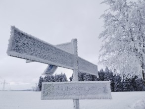 Icy trail sign covered with snow in a snowy winter landscape, Rennsteig, Frankenwald nature park