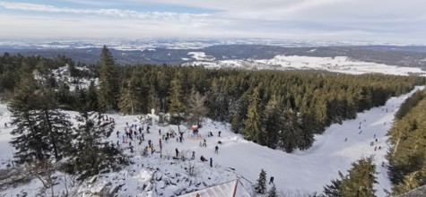 Winter landscape with snow-covered forest and people skiing, ski lift at Ochsenkopf, Fichtelgebirge