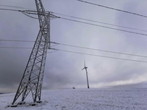 View of a wind turbine and a power pole in a snowy winter landscape, Rennsteig, Frankenwald nature