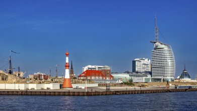 Lighthouse and modern buildings at the harbor under clear skies, The City of Bremen