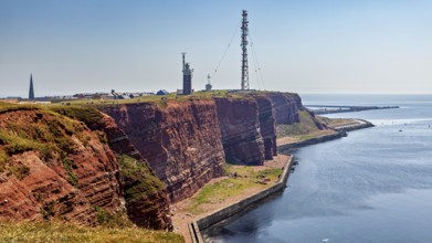 Red cliffs with lighthouse under blue sky on the coast, the high-seas island of Heligoland in the