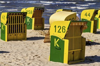 Yellow and green beach chairs stand in the sun on the beach with a view of the sea, beach chairs on