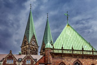Gothic church towers with green roofs rise against a dramatic cloudy sky, The center of the