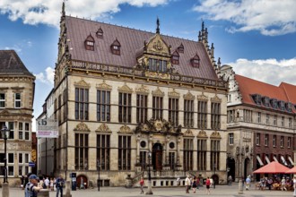 Magnificent Renaissance building with ornate details surrounded by people on a sunny square, The