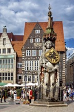 City center scene with the Roland statue in front of impressive half-timbered houses under a blue