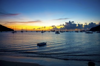 Romantic evening mood over Tyrrell Bay with many sailboats sailing yachts, moored rowing boat on